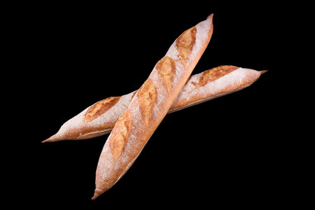 Freshly baked homemade bread isolated on black. French bread baguette. Healthy eating and traditional bakery, baking bread conceptの写真素材
