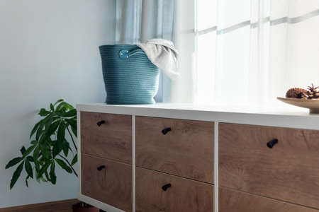 Laundry basket with gray towel. Interior of white stylish room with laundry basket.の写真素材