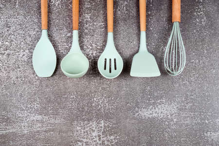 Kitchen utensils, home kitchen tools, mint rubber accessories on dark background. Restaurant,...