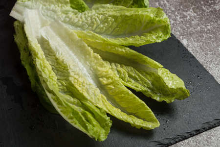 Fresh washed green salad on black slate cutting board ready for cooking. Ingredients for cooking, vegetarian diet, healthy eatingの写真素材