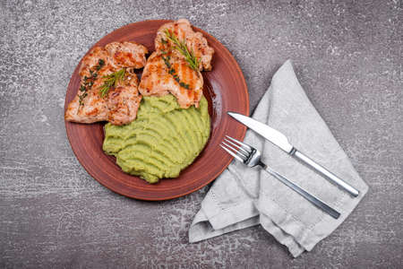 Delicious grilled chicken with herbs and green puree. Chicken fillet with mashed potatoes, green peas and pesto sauce. Healthy homemade food. Flat lay, top viewの写真素材