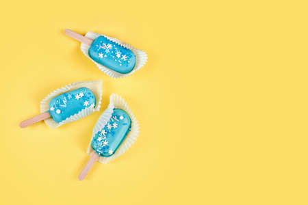 Blue mint ice creams on yellow background. Tasty and refreshing ice cream on sticks. Minimal summer...