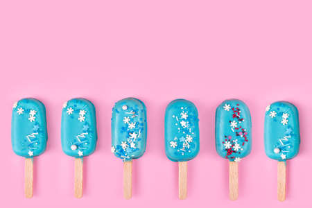 Blue mint ice creams on pastel pink background. Tasty and refreshing icecream on sticks. Minimal summer concept. Flat lay, free copyspace for textの写真素材