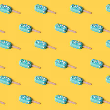 Blue mint ice cream  on yellow background. Tasty and refreshing ice cream on sticks. Seamless pattern, minimal summer concept. Flat lay.の写真素材