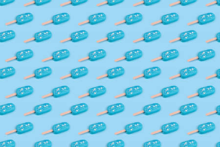 Tasty and refreshing ice cream on sticks. Seamless pattern blue mint ice cream  on blue background. Minimal summer concept. Flat lay, free copyspace for textの写真素材