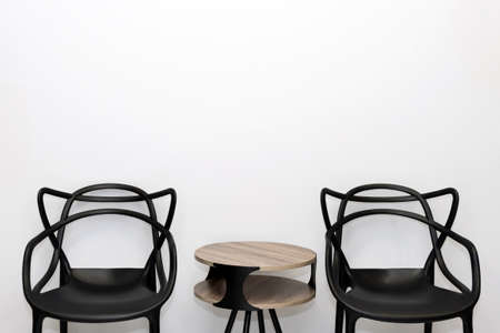 Front view of modern, simple chairs against gray wall in a minimal style waiting room interior. Chairs in waiting room of doctor's office with copy space for textの写真素材