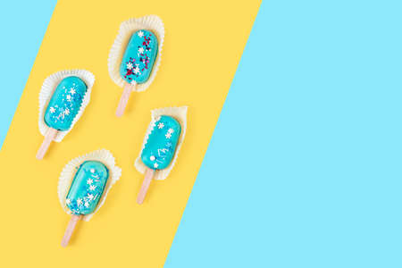 Blue mint ice cream  on yellow and blue pastel background. Tasty and refreshing ice cream on sticks....