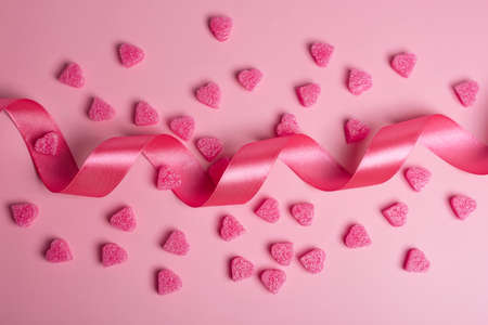 Pink hearts on pastel pink background with ribbon. Romantic background for Valentine's Day....