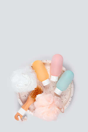 Cosmetic products for spa and bath accessories on gray background. Colorful plastic containers for...