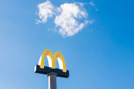 Kyiv, Ukraine - March 06, 2021: McDonald's restaurants logo in the blue sky. The McDonald's Corporation, the world's largest chain of fast food restaurantsのeditorial素材