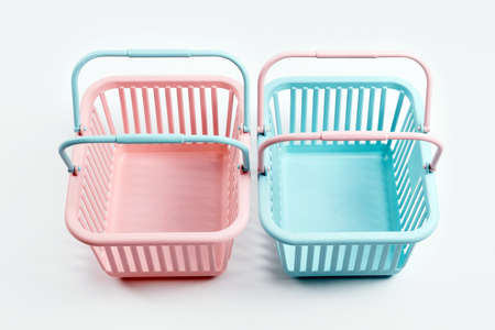 Colorful plastic shopping baskets. Empty pink and blue supermarket baskets on gray background. Creative minimalist design, online shopping. Black friday and sale conceptの写真素材