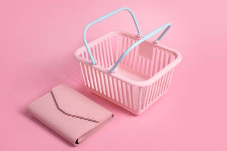 Colorful plastic shopping baskets with leather wallet. Empty pink and blue supermarket basket on pink pastel background. Creative design, shopping, black friday, discount, advertising, sale conceptの写真素材