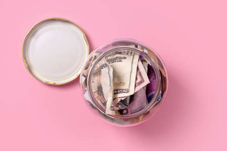 American dollars in glass money jar, top view, financial, saving. Money box, jar full of cash, save money concept, expense planning and control, free space for textの写真素材