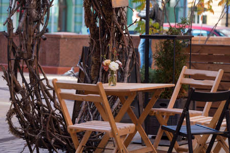 Empty chairs in outdoor cafe or restaurant. Wooden tables and chairs at sidewalk cafeの写真素材