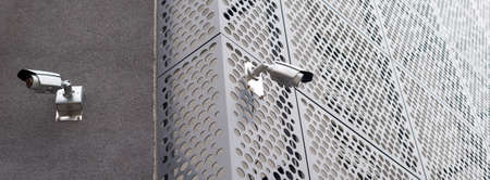 Security cameras on modern building. Professional surveillance camera. CCTV on the wall with LED IR lights. Security system, technology concept. Video equipment for safety system area control outdoor.の写真素材