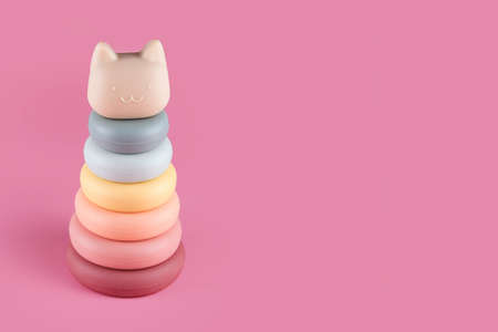 Silicone pyramid or tower toy for babies and toddlers. First soft baby toys. Colorful educational montessori kids toys on pink background.の写真素材