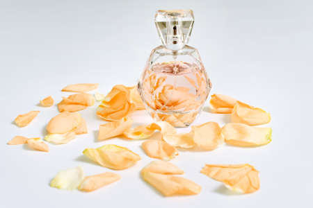 Perfume bottle with flower petals on light background. Perfumery, fragrance collection. Women...