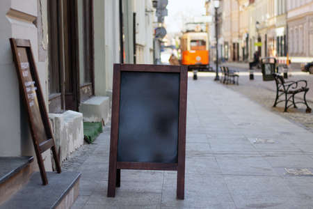 Signboard on the street. Empty menu board stand. Restaurant sidewalk sign board. Freestanding board near outdoor cafe. Copyspace for text, selective focus.の写真素材