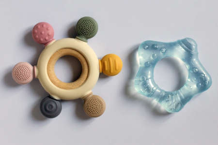 Plastic and wooden rattle toys for toddlers, toys for babies isolated on blue background. Soft material for childrens teeth, child activities, rattles, multicoloredの写真素材