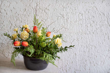 Bouquet of pink tulips in flower pot.Tulips and green herbs and leaves in floristic composition with free space for textの写真素材