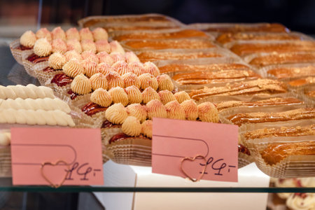Eclairs on the shelf of a pastry shop or cafe. Tasty french sweets on window shop, delicious...
