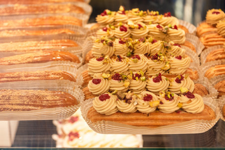 Eclairs on the shelf of a pastry shop or cafe. Tasty french sweets on window shop, delicious...