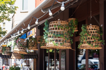 Wicker lampshades in an outdoor street cafe. Decorating hanging lantern lamps in wooden wicker made from bamboo. vintage asian restaurant decorations.の写真素材