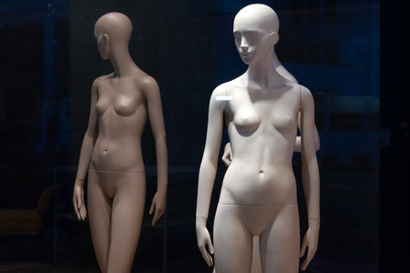 Naked female mannequins in the shop window. Fashion clothing woman mannequin in the store
