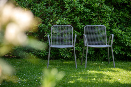 Metal chairs in spring garden. Metal garden furniture for picnics and birdwatching.