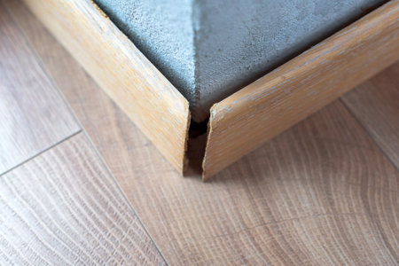 Broken wooden skirting revealing the cracks and imperfections along the edge. The image highlights issues related to home maintenance and the effects of wear and damages over timeの写真素材