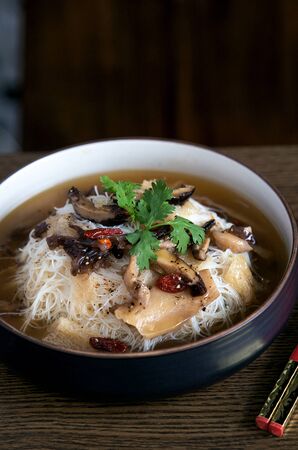Fusion asian noodle soup with mushrooms in bowlの写真素材