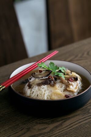 Fusion asian noodle soup with mushrooms in bowlの写真素材
