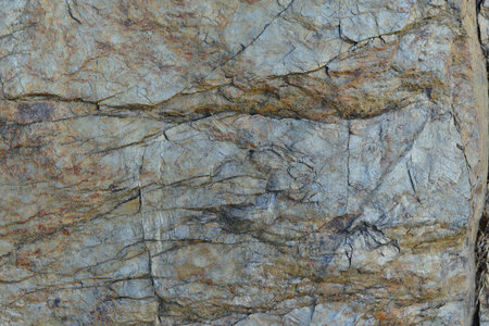 Stone texture background. Close up of rock surface with cracks and scratches.