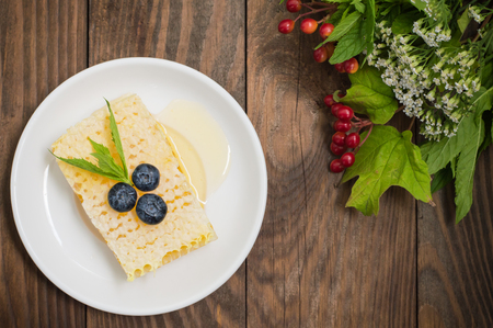 Honeycomb with blueberries and mint. Wooden backgroundの写真素材