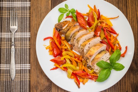Roast duck breast with vegetable saute on a plate. Wooden background. Top viewの写真素材