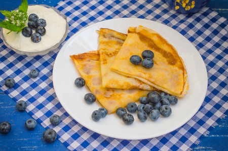 Pancakes with blueberries, whipped cream and a sprig of mint and lemon balmの写真素材