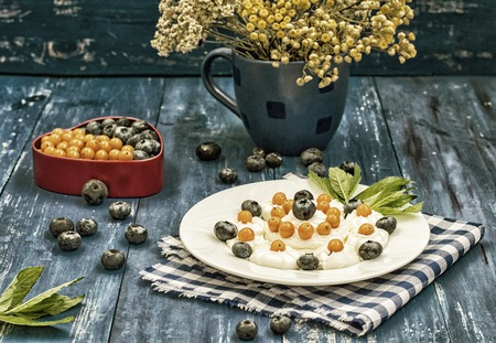 Blueberries and buckthorn laid out in the shape of a heart with cream meringueの写真素材