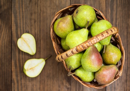 Ripe pears in a basket on a wooden backgroundの写真素材