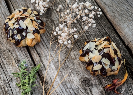Profiteroles glazed in chocolate and sprinkled with walnut shavingsの写真素材