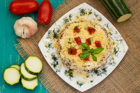 The cake of zucchini with cheese, tomato and basil. Wooden background.の写真素材