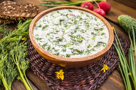 Summer cold soup with radish, cucumber, and dill on wooden table.の写真素材