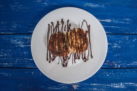 Cheesecakes covered with chocolate on a blue wooden background