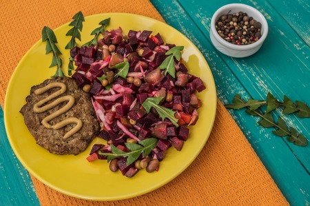 Salad Vinaigrette of beets and steak on a wooden background