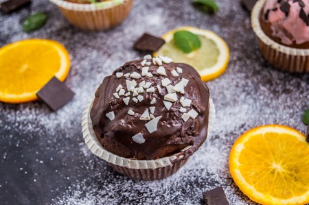 Cupcakes with fruit and powdered sugar on a dark backgroundの写真素材