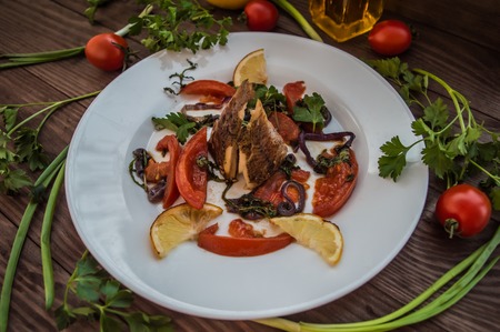 Pike baked with vegetables on the table. Wooden rustic backgroundの写真素材