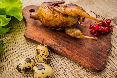 Roasted quail with greens on a wooden Boards. Top viewの写真素材