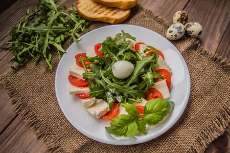 Arugula Salad - Caprese Salad. Wooden background. Top view