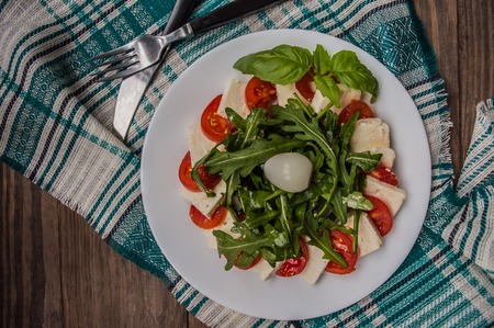 Arugula Salad - Caprese Salad. Wooden background. Top view