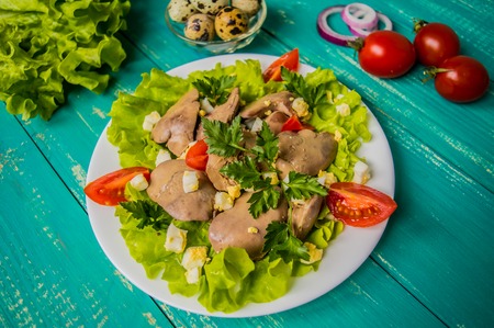 Chicken liver and quail eggs for breakfast. At the turquoise wooden background. Top view.の写真素材