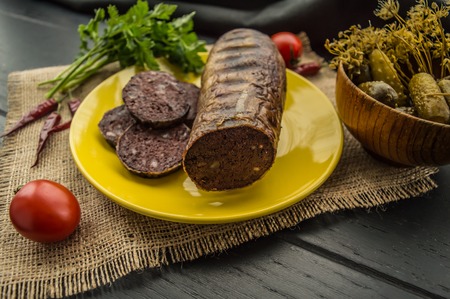 Homemade blood sausage with offal on a black wooden backgroundの写真素材